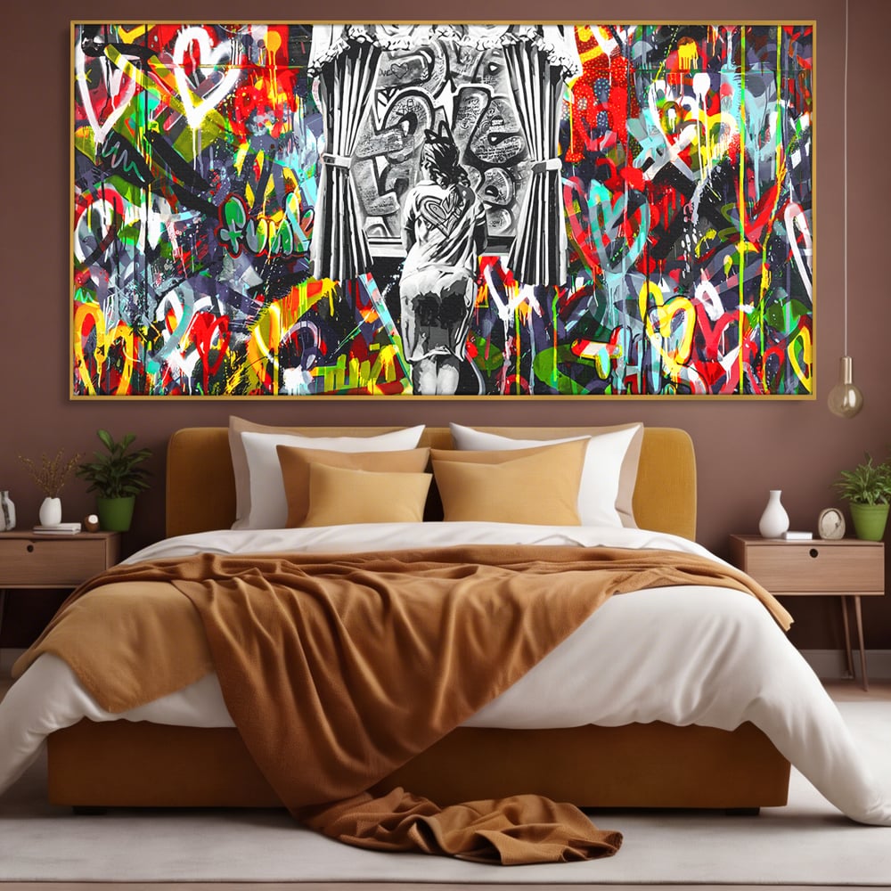 Tablou canvas cu tablou canvas cu graffiti urban si o silueta, in rama de aluminiu auriu, pe perete intr-un dormitor